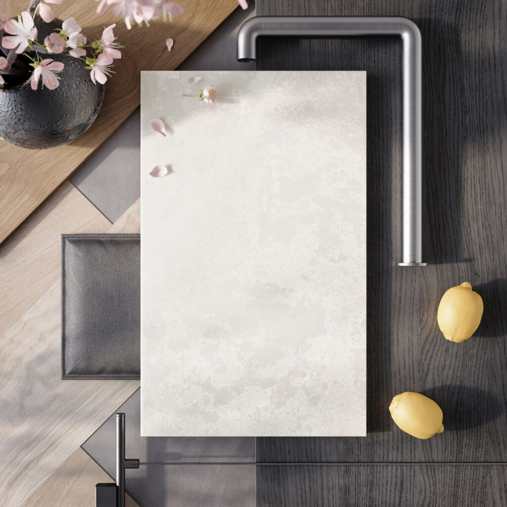 Modern kitchen sink setup with silver faucet, lemons, leather wallet, wooden board, and cherry blossoms.
